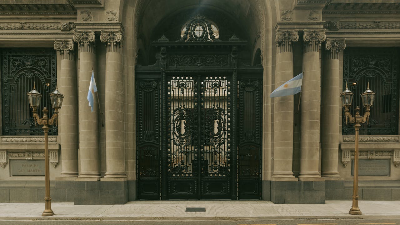 Elegant entrance of Palacio San Martin, Buenos Aires with ornate gates and Argentine flags.
