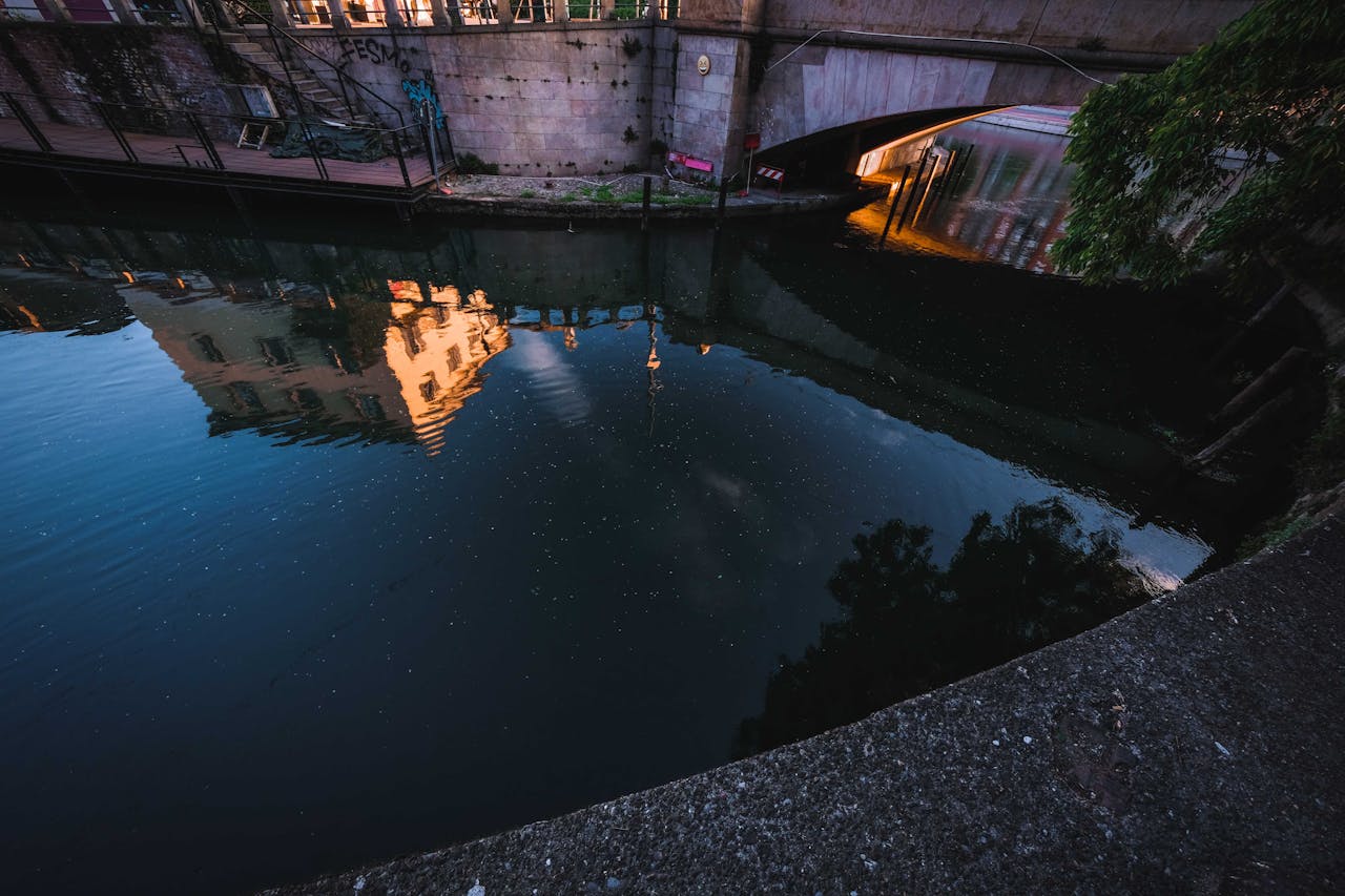 Peaceful canal reflection in Milan, capturing the historic architecture at dusk.